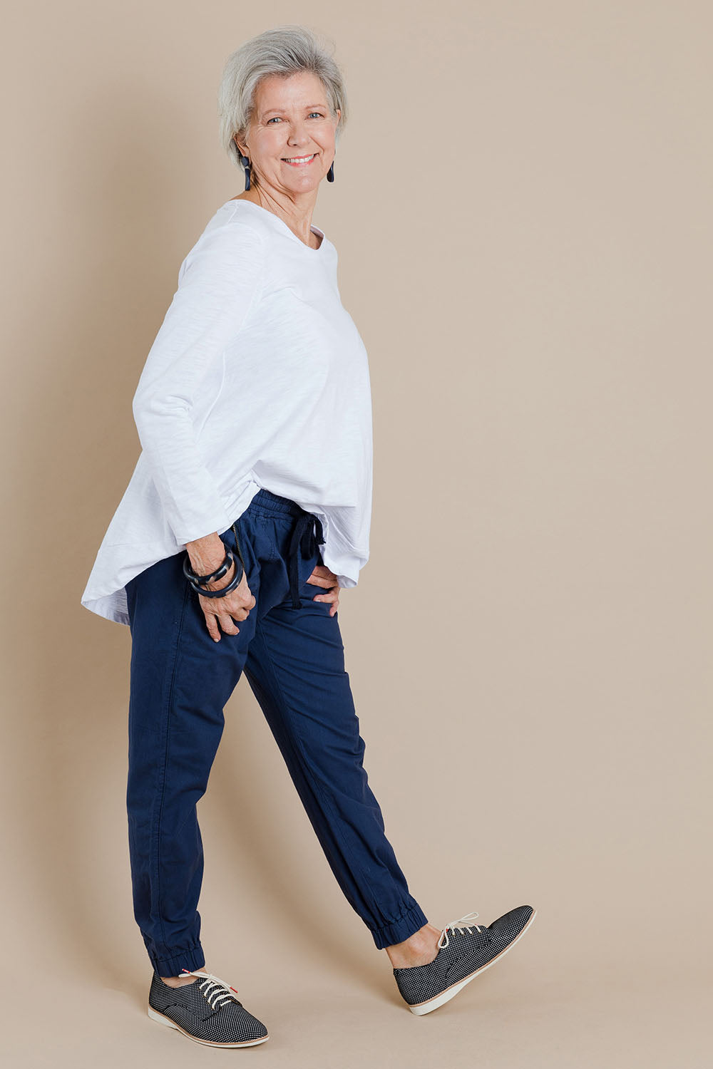 Model Elise wearing size 10 of The Weekender Pant in colour Navy (Blue), from the front, showing the whole outfit