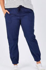 Model Mae wearing size 16 of The Weekender Pant in colour Navy (Blue), from the front, cropped image