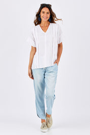 Model Clementine wearing size 10 of The Chambray Curved Hem Pant in colour Chambray (Blue), from the front, showing the whole outfit