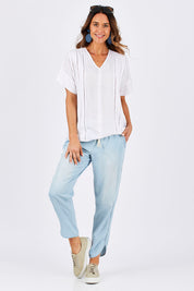 Model Clementine wearing size 10 of The Chambray Curved Hem Pant in colour Chambray (Blue), from the front, showing the whole outfit