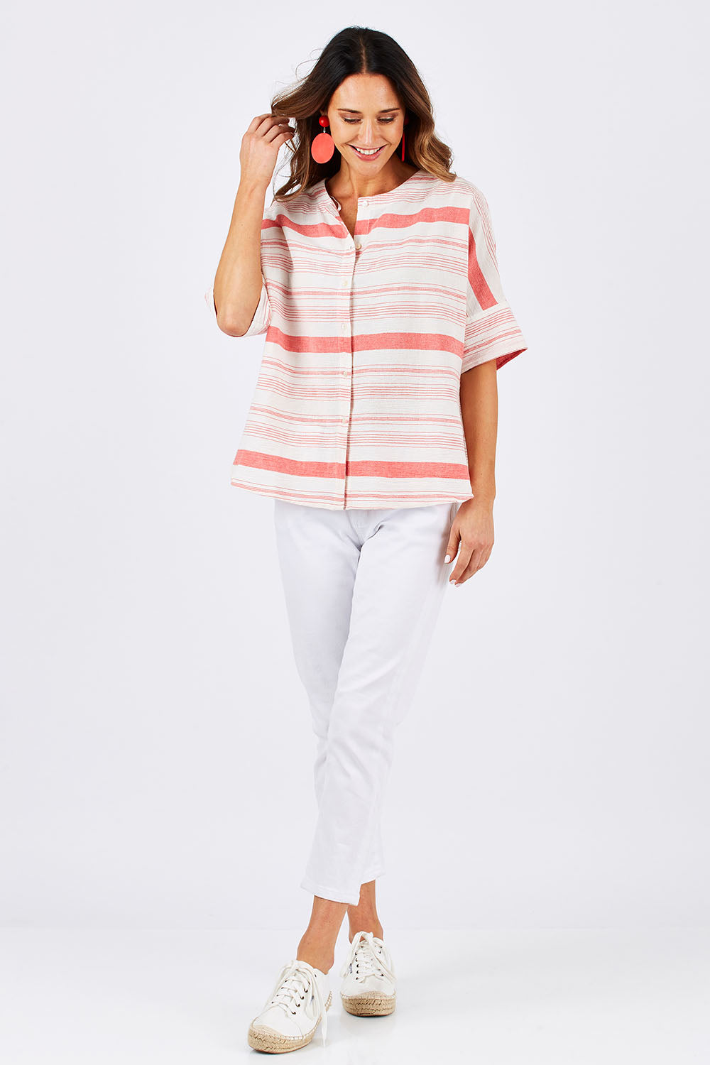 Model Clementine wearing size 10 of The Stripe Button Through Top in colour Coral (Pink), from the front, showing the whole outfit