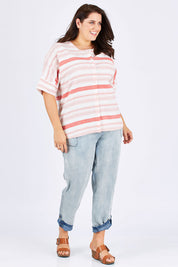 Model Mae wearing size 18 of The Stripe Button Through Top in colour Coral (Pink), from the front, showing the whole outfit