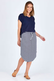 Model Riina wearing size 10 of The Weekender Comfort Skirt in colour Stripe (Black), from the front, showing the whole outfit