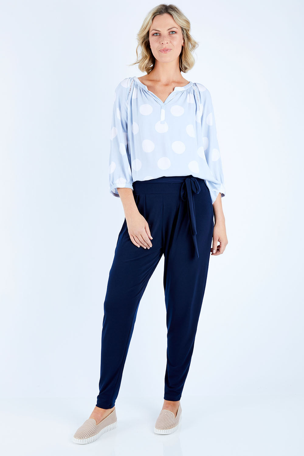 Model Chelsea wearing size 10 of The Comfort Pant in colour Navy (Blue), from the front, showing the whole outfit