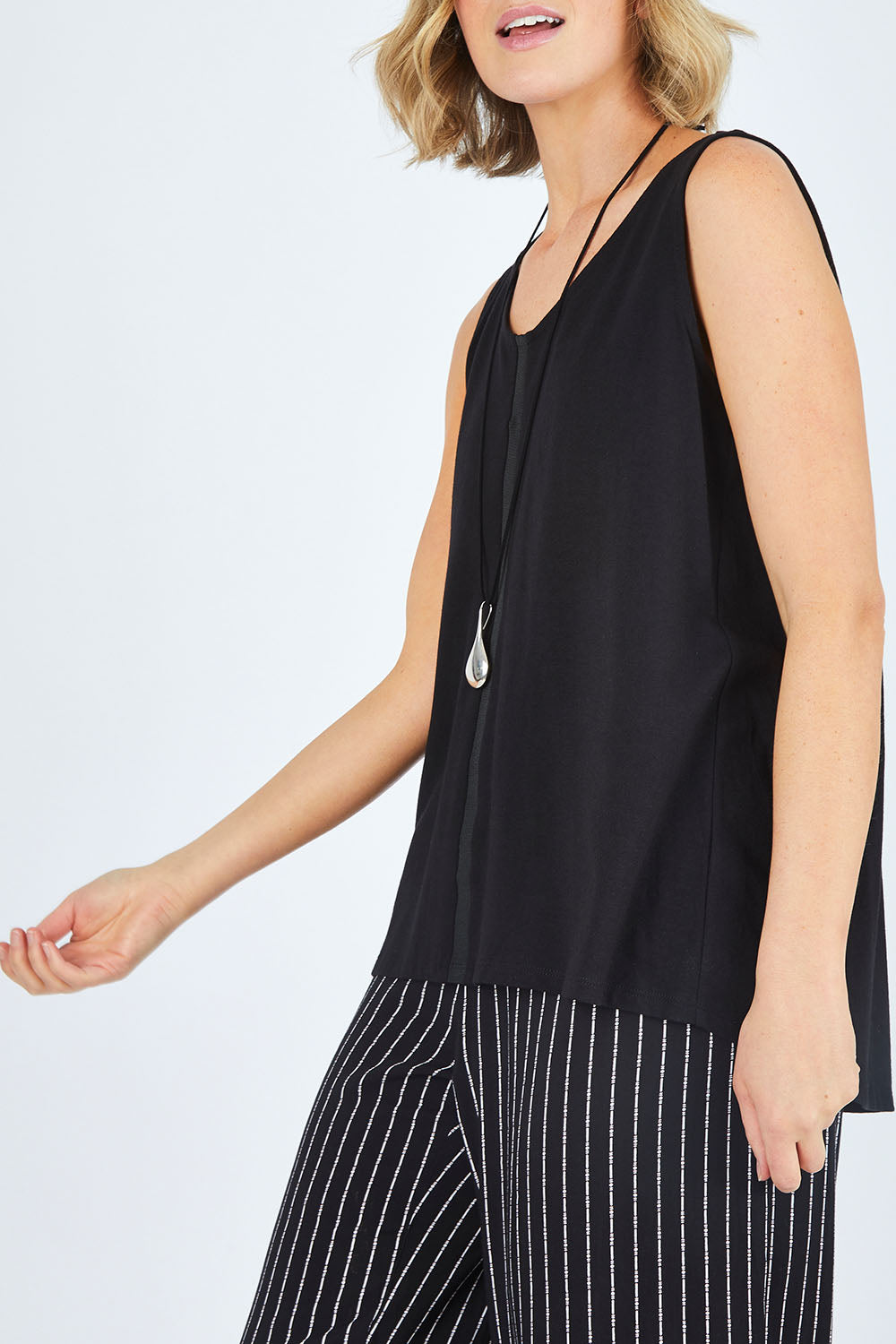 Model Chelsea wearing size 10 of The Cotton Bamboo Tank in colour Black (Black), from the front, cropped image
