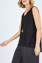 Model Chelsea wearing size 10 of The Cotton Bamboo Tank in colour Black (Black), from the front, cropped image
