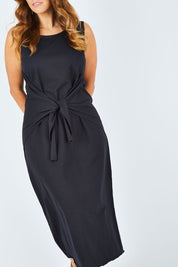 Model Laura wearing size 14 of The Tie Waist Tank Dress in colour Black (Black), from the front, cropped image