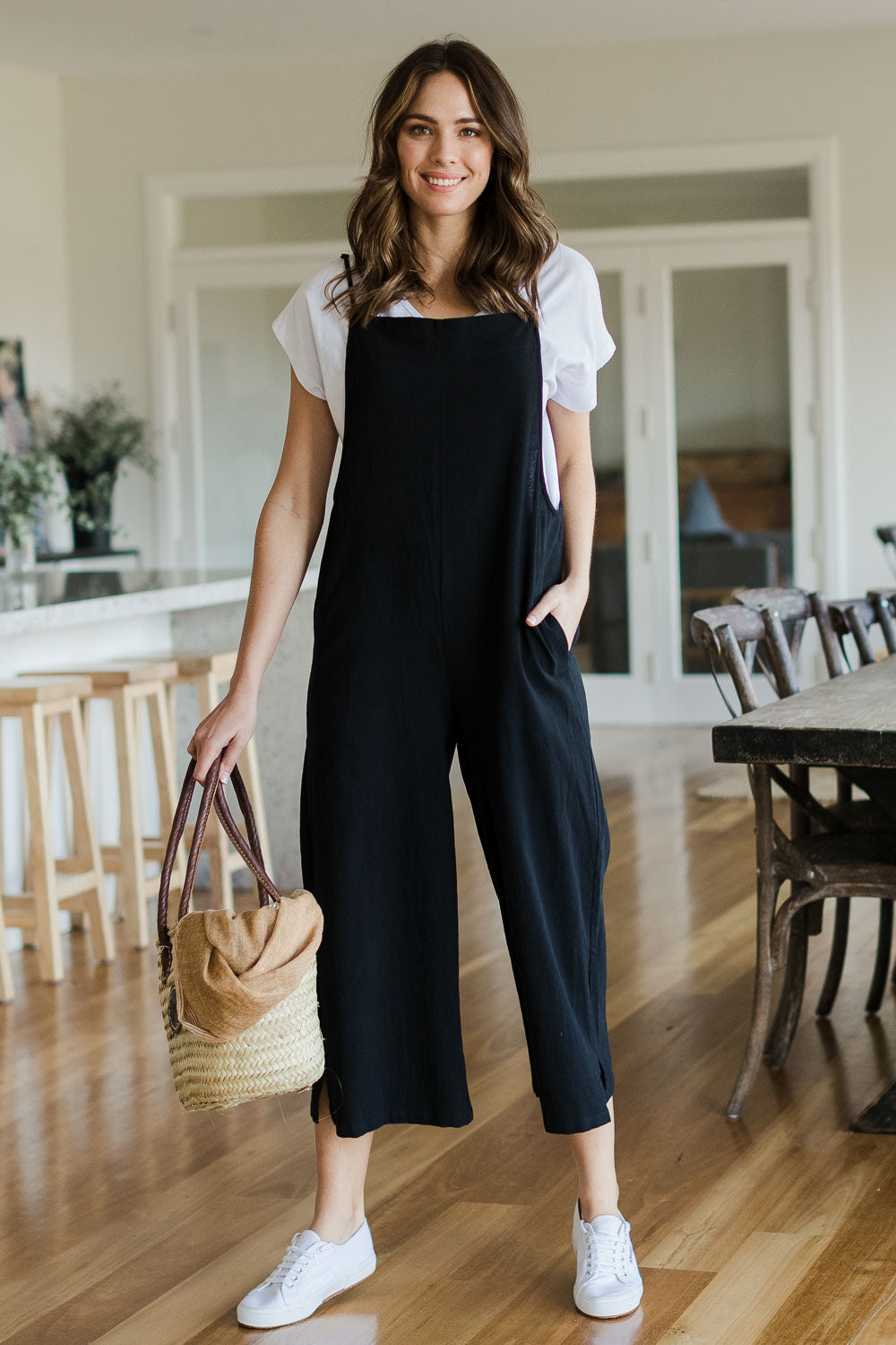 Model Madeline wearing size 10 of The Easy Day Jumpsuit in colour Black (Black), from the front, showing the whole outfit