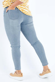 Model Sasha-Lee wearing size 16 of The Mid Rise Skinny Jean in colour Lightdenim (Blue), from the back