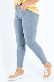 Model Sasha-Lee wearing size 16 of The Mid Rise Skinny Jean in colour Lightdenim (Blue), from the front, cropped image