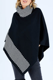 Model Chelsea wearing size S-M of The Patterned Removable Roll Neck Poncho in colour Blackprint (Black), from the front, cropped image