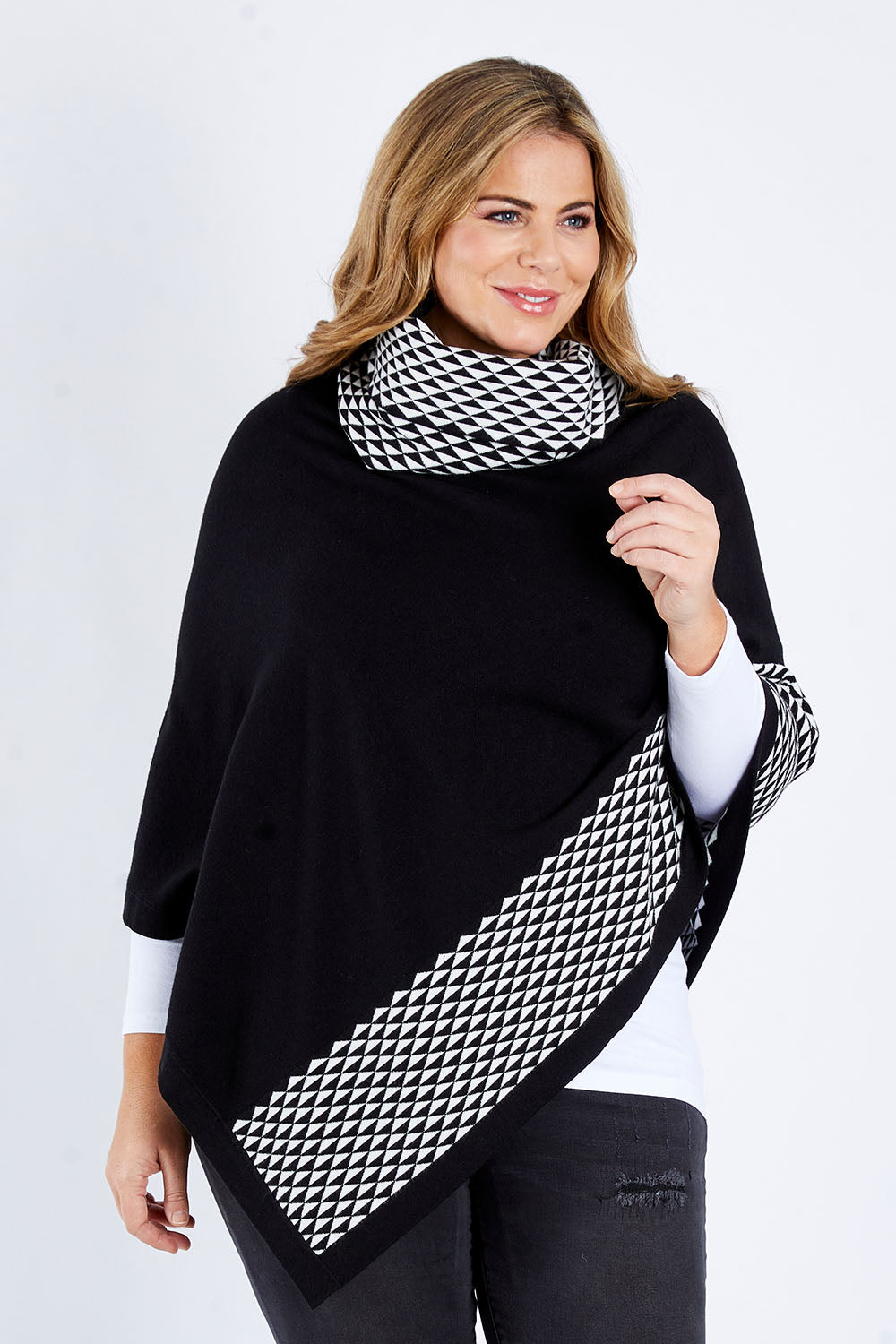 Model Fiona wearing size L-XL of The Patterned Removable Roll Neck Poncho in colour Blackprint (Black), from the front, cropped image