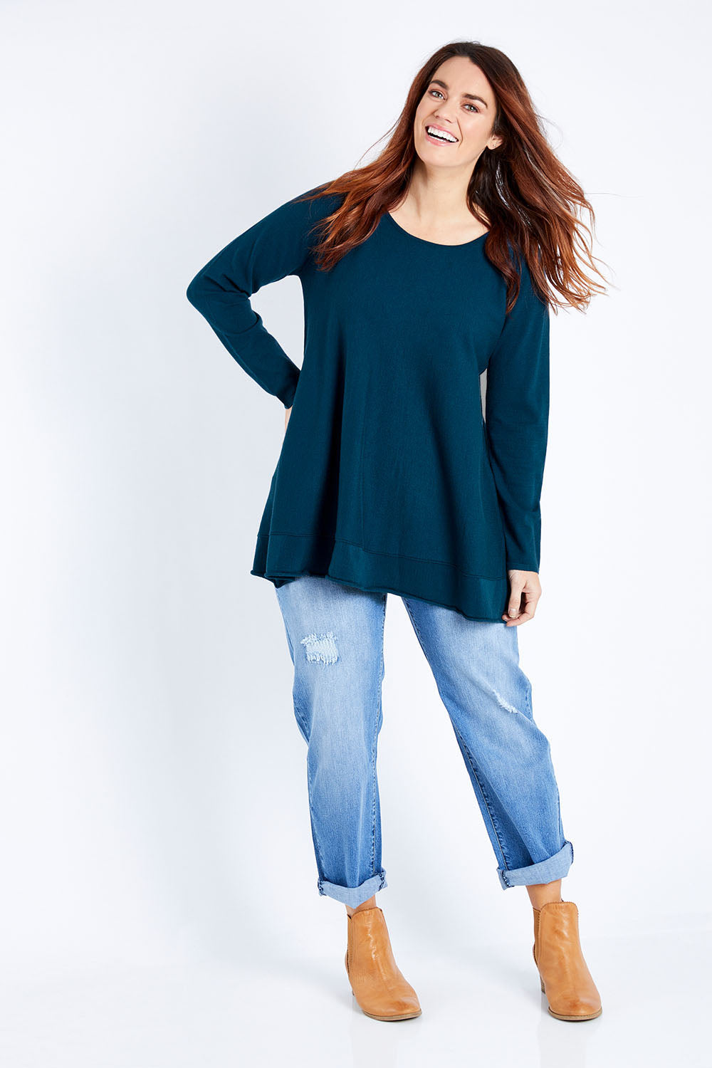 Model Laura wearing size M of The Swing Knit in colour Petrol (Blue), from the front, showing the whole outfit