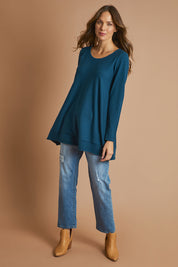 Model Madeline wearing size S of The Swing Knit in colour Petrol (Blue), from the front, showing the whole outfit