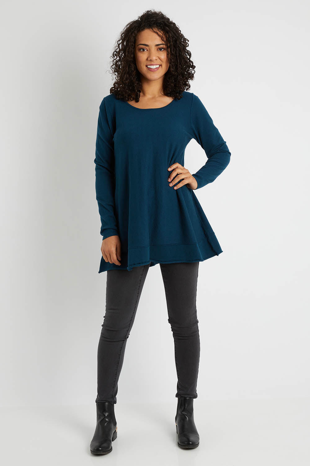 Model Pamela wearing size S of The Swing Knit in colour Petrol (Blue), from the front, showing the whole outfit