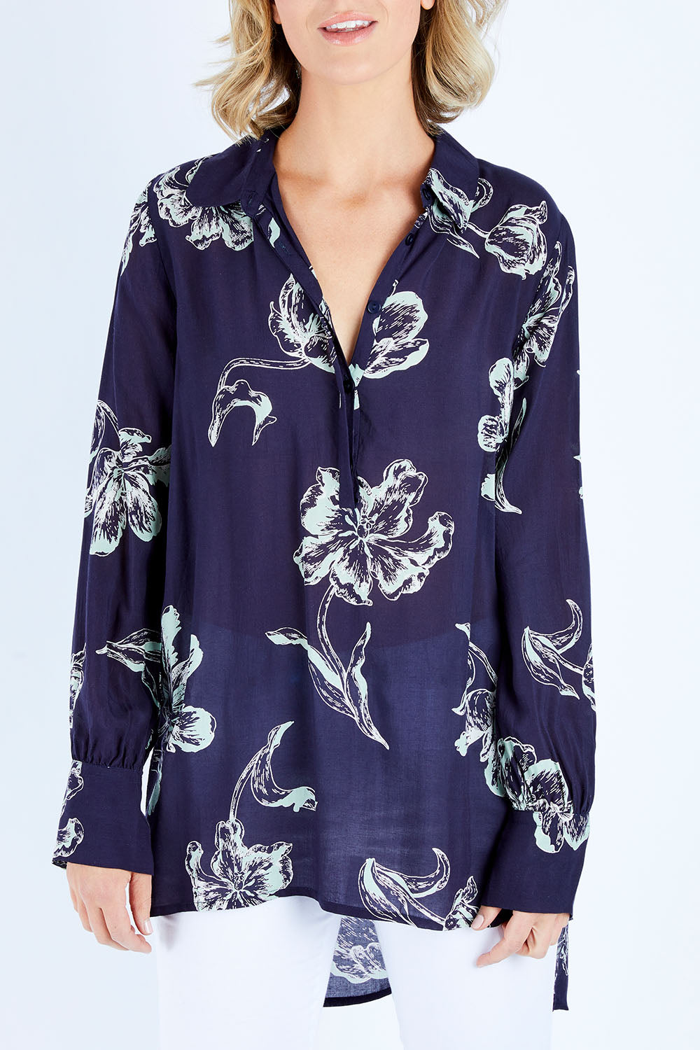 Model Chelsea wearing size 10 of The Longline Button Shirt in colour Navyprint (Blue), from the front, cropped image