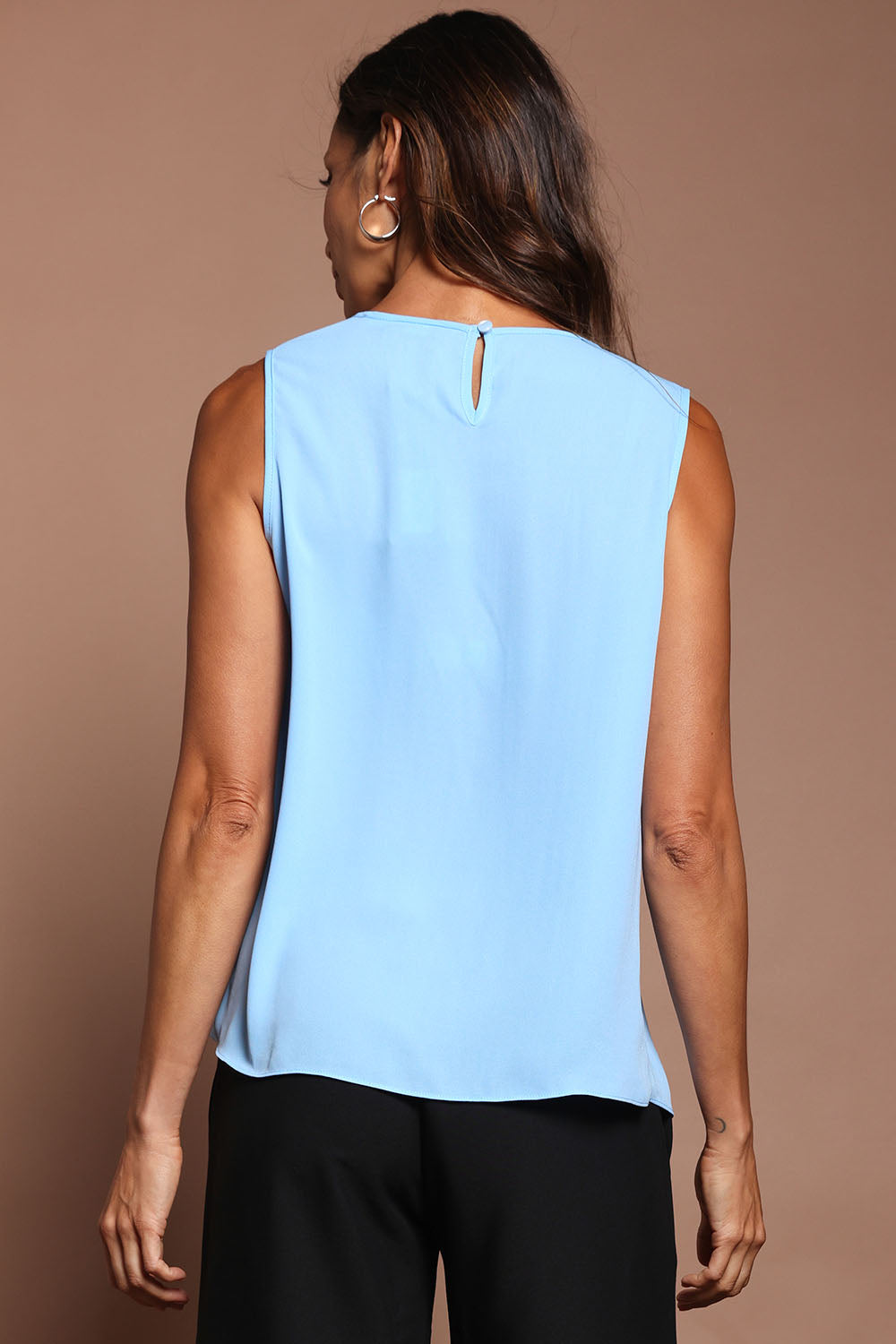 Model Amanda wearing size 10 of The Asymmetrical Tank Top in colour Sky (Blue), from the back