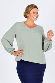 Model Fiona wearing size 16 of The Pleated Sleeve Top in colour Sage (Green), from the front, cropped image