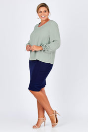 Model Fiona wearing size 16 of The Pleated Sleeve Top in colour Sage (Green), from the front, showing the whole outfit