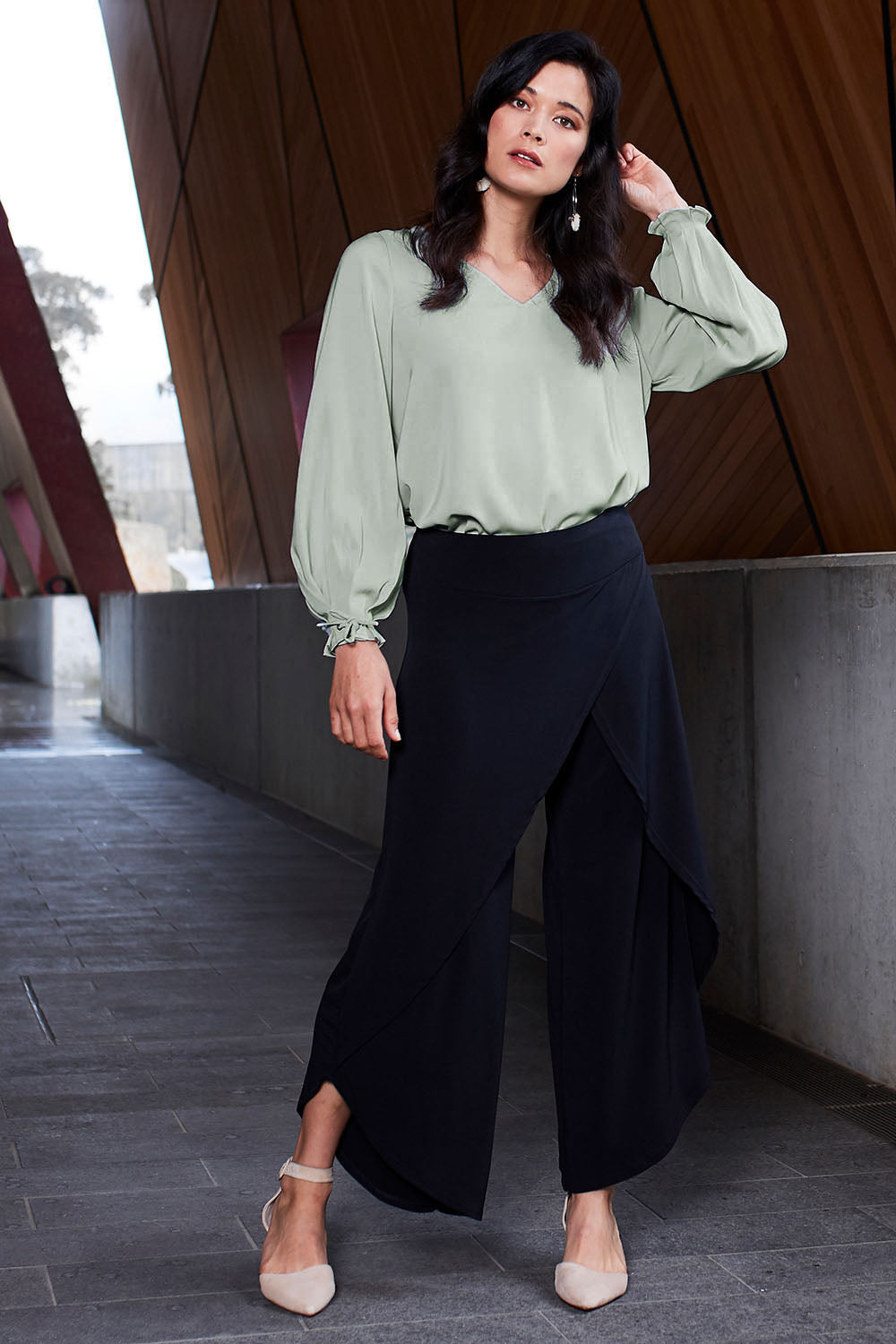 Model Miranda wearing size 10 of The Pleated Sleeve Top in colour Sage (Green), from the front, showing the whole outfit
