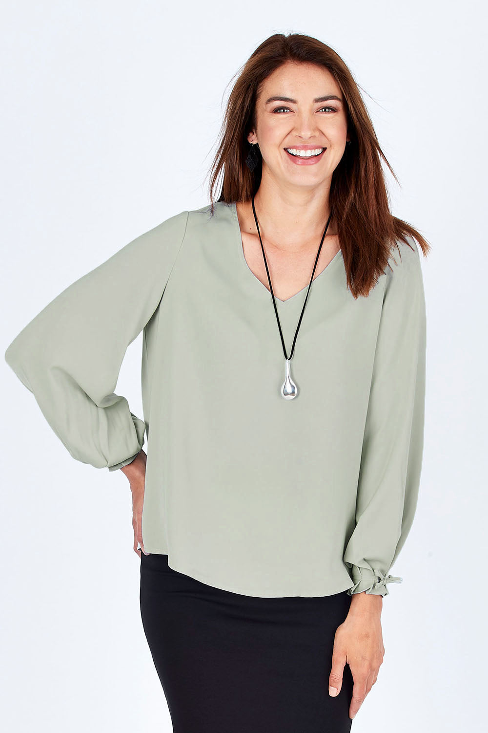 Model Rebecca wearing size 10 of The Pleated Sleeve Top in colour Sage (Green), from the front, cropped image
