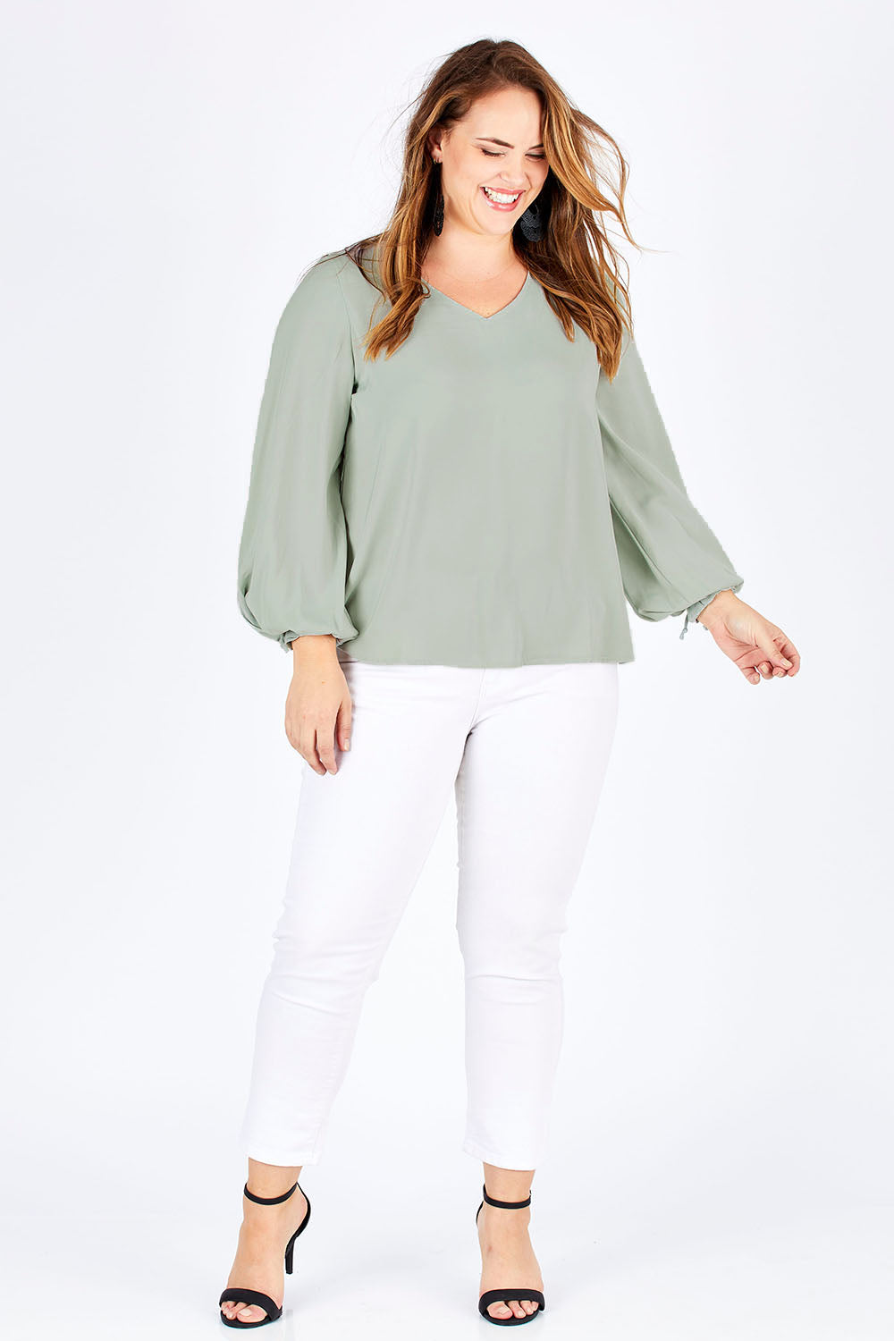 Model Sophie wearing size 14 of The Pleated Sleeve Top in colour Sage (Green), from the front, showing the whole outfit