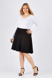 Model Ljubenka wearing size 18 of The Ponte Flip Skirt in colour Black (Black), from the front, showing the whole outfit