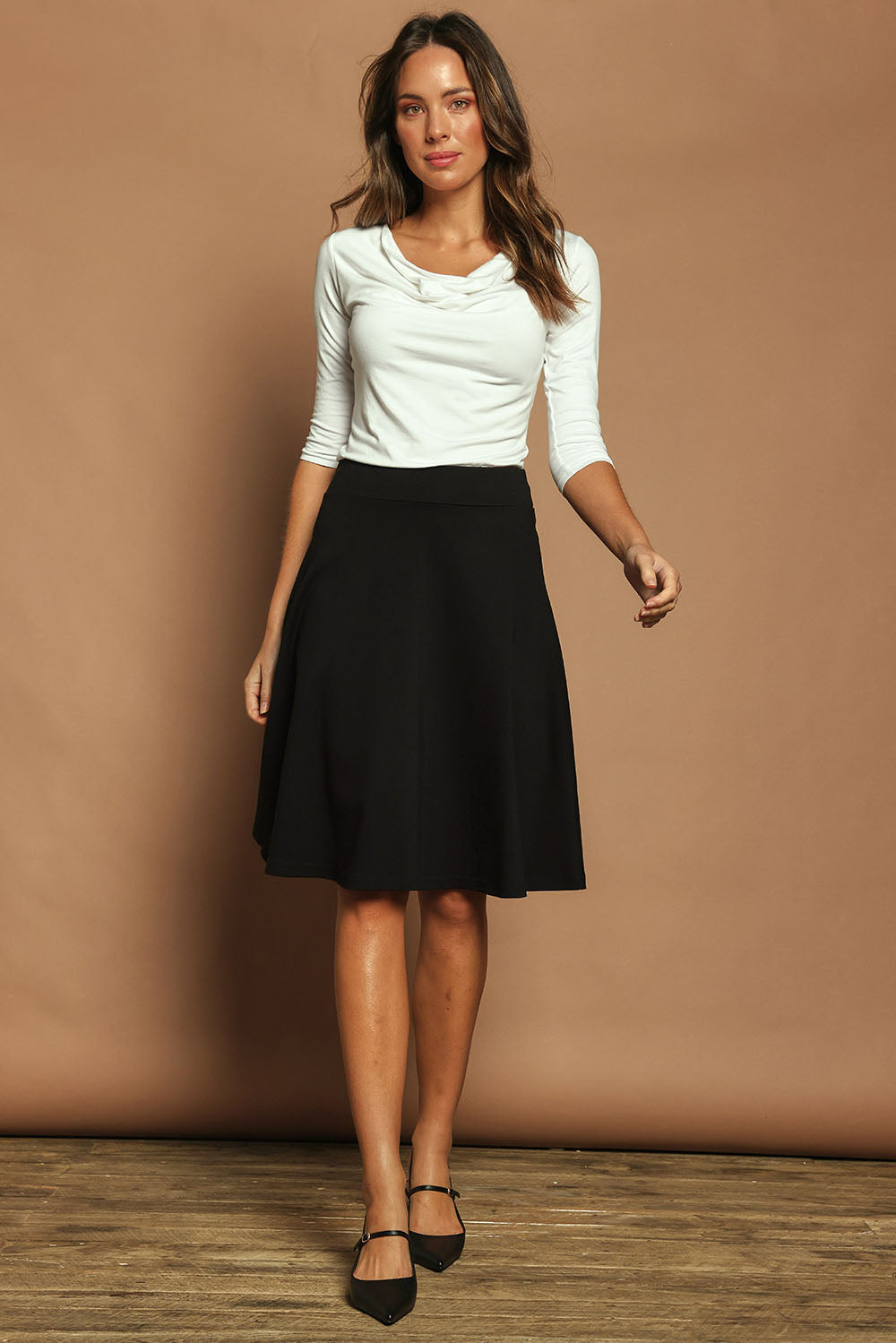 Model Madeline wearing size 10 of The Ponte Flip Skirt in colour Black (Black), from the front, showing the whole outfit