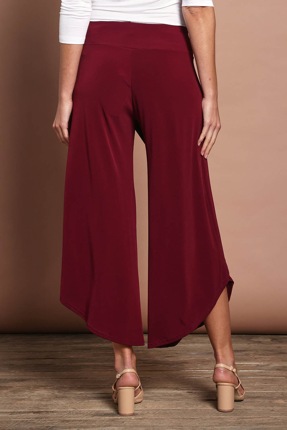 Model Madeline wearing size 10 of The Cross Over Pant in colour Port (Purple), from the back