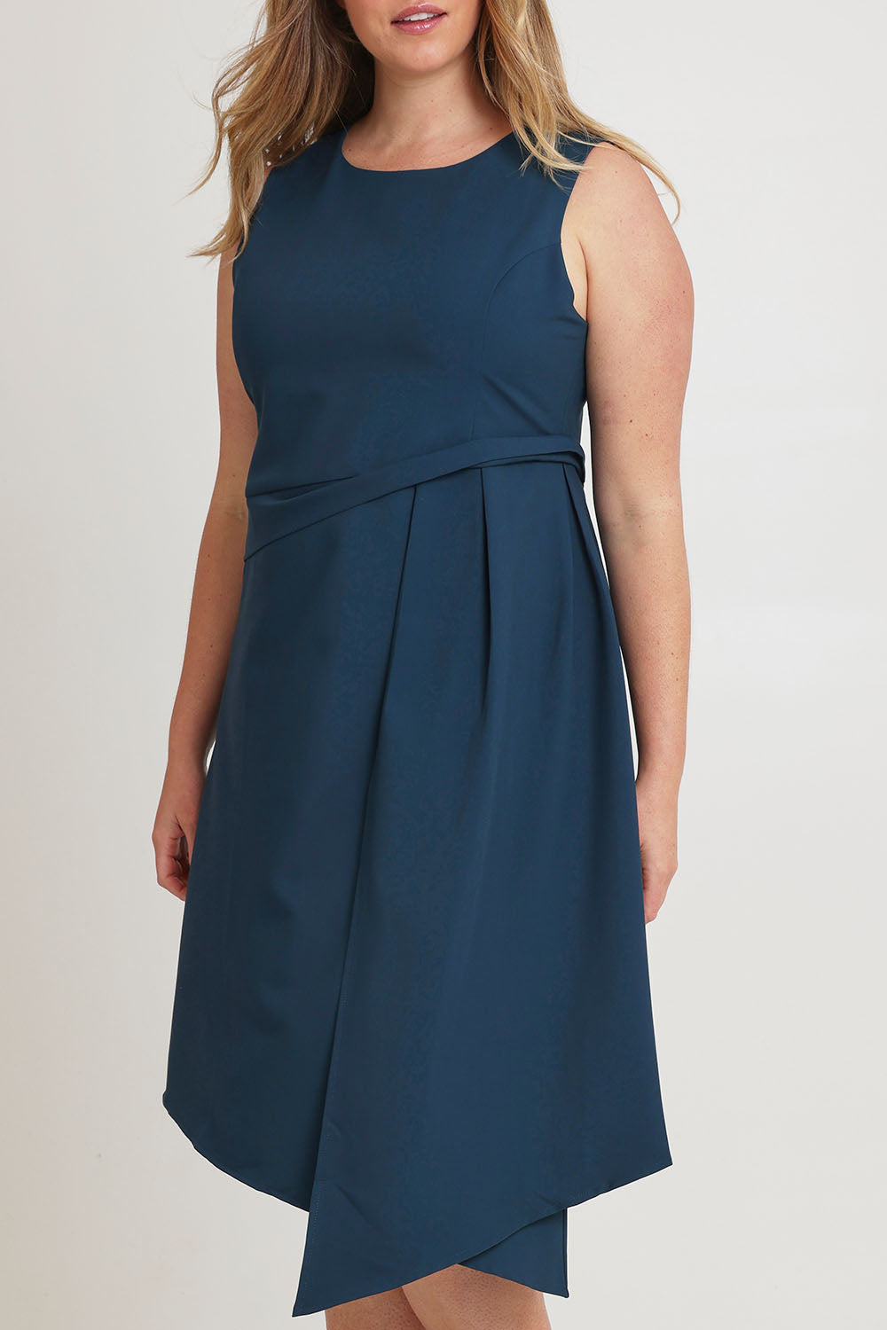 Model Chanel wearing size 16 of The Side Pleated Dress in colour Deepocean (Blue), from the front, cropped image