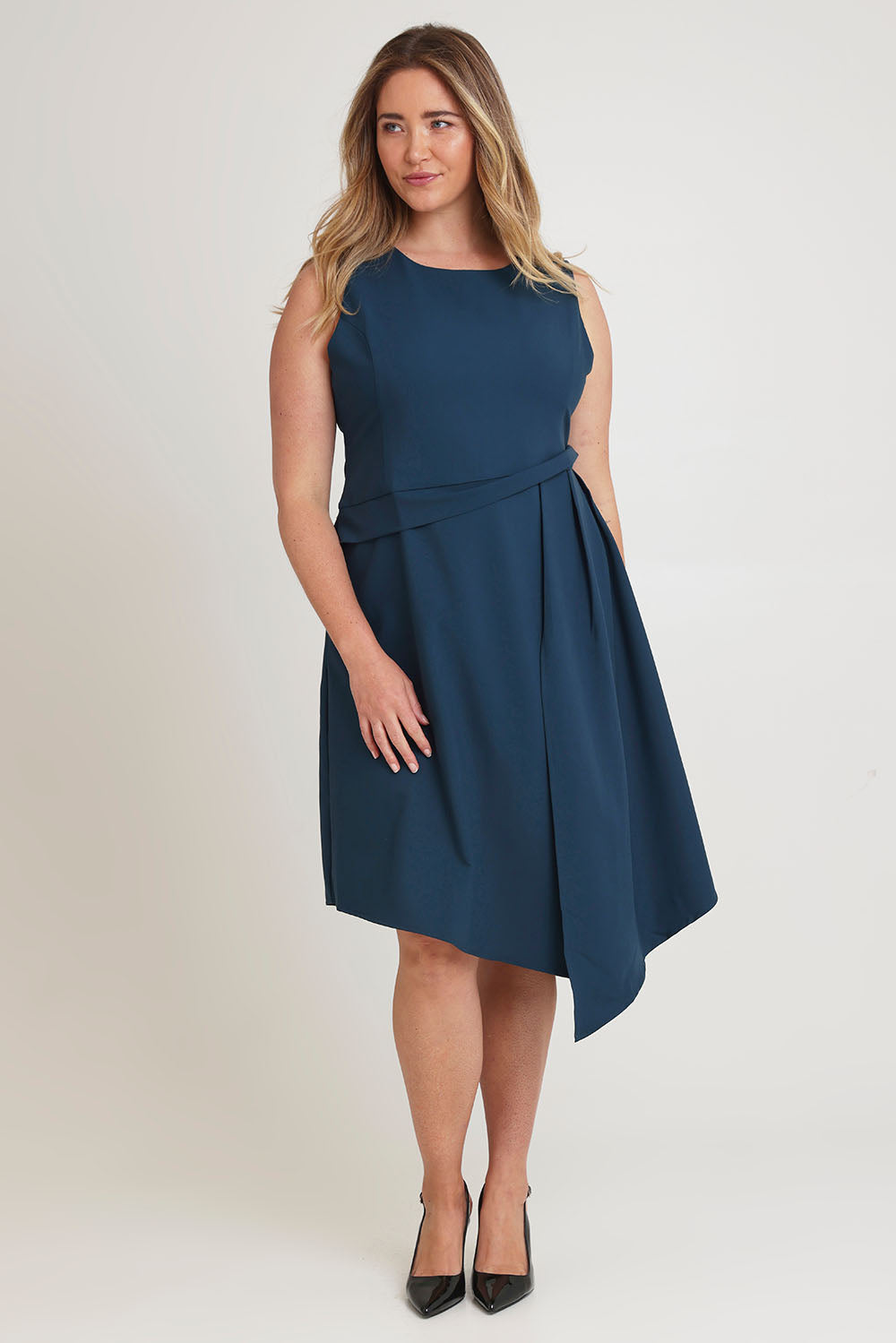 Model Chanel wearing size 16 of The Side Pleated Dress in colour Deepocean (Blue), from the front, showing the whole outfit