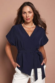 Model Madeline wearing size 10 of The Kimono Top in colour Navy (Blue), from the front, cropped image