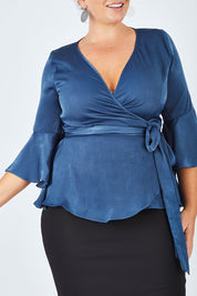 Model Fiona wearing size 16 of The Luxe Wrap Top in colour Opal (Blue), from the front, cropped image