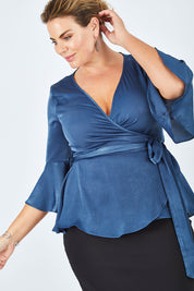 Model Fiona wearing size 16 of The Luxe Wrap Top in colour Opal (Blue), from the front, cropped image