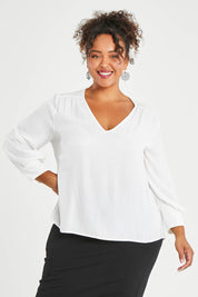 Model Alexis wearing size 16 of The Luxe Dobby Blouse in colour White (White), from the front, cropped image