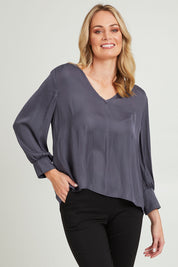 Model Grace wearing size 10 of The Luxe V Neck Blouse in colour Slate (Grey), from the front, cropped image
