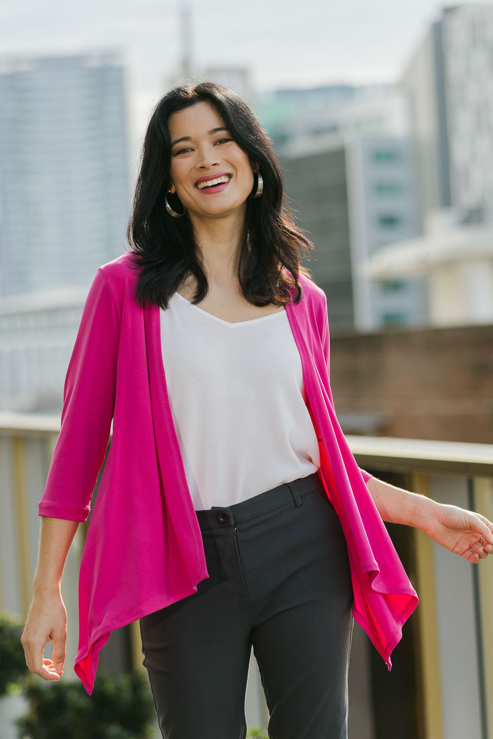 Model Miranda wearing size 10 of The Drape Cardi in colour Hotpink (Pink), from the front, showing the whole outfit