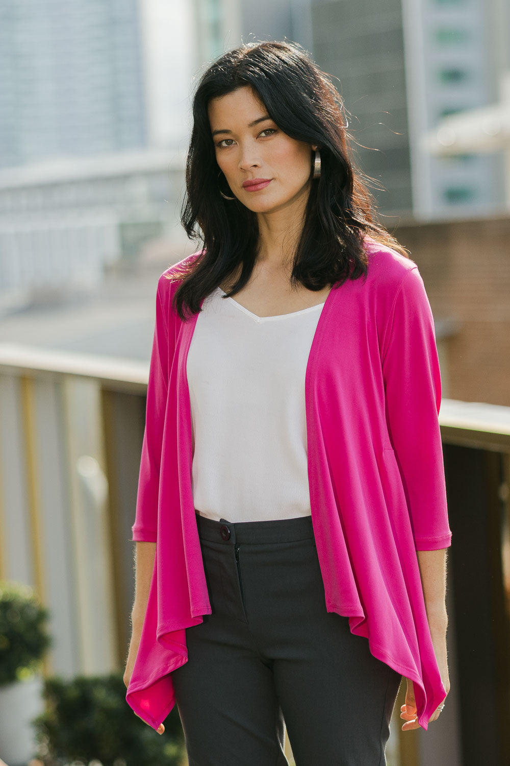 Model Miranda wearing size 10 of The Drape Cardi in colour Hotpink (Pink), from the front, showing the whole outfit