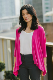 Model Miranda wearing size 10 of The Drape Cardi in colour Hotpink (Pink), from the front, showing the whole outfit