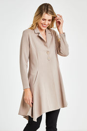 Model Kelly wearing size 10 of The Asymmetrical Hem Coat in colour String, from the front, cropped image