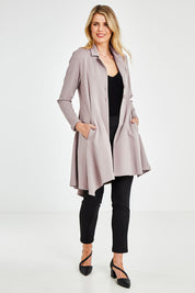 Model Kelly wearing size 10 of The Asymmetrical Hem Coat in colour String, from the front, showing the whole outfit