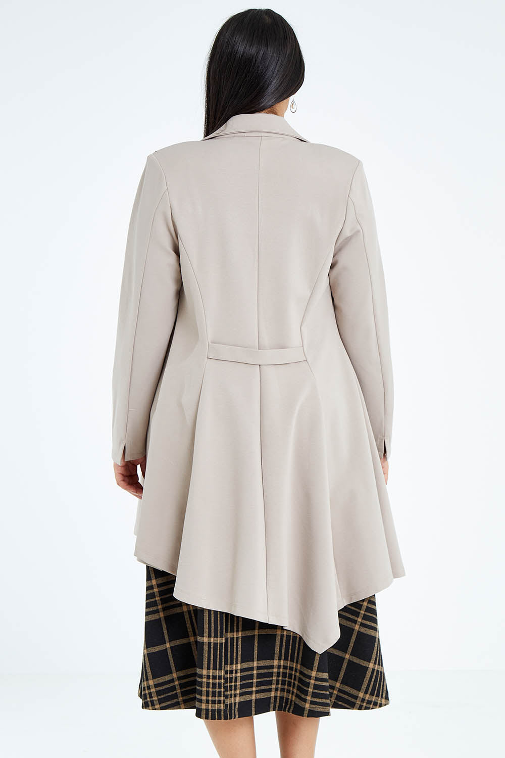 Model Sasha-Lee wearing size 16 of The Asymmetrical Hem Coat in colour String, from the back