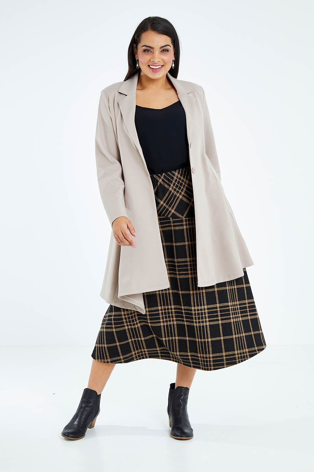 Model Sasha-Lee wearing size 16 of The Asymmetrical Hem Coat in colour String, from the front, showing the whole outfit