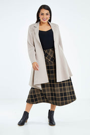 Model Sasha-Lee wearing size 16 of The Asymmetrical Hem Coat in colour String, from the front, showing the whole outfit