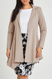 Model Terri-Leigh wearing size 14 of The Asymmetrical Hem Coat in colour String, from the front, cropped image