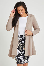 Model Terri-Leigh wearing size 14 of The Asymmetrical Hem Coat in colour String, from the front, cropped image