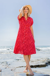 Model Riina wearing size 10 of The Printed Cotton V Neck Dress in colour Bamboo (Red), from the front, showing the whole outfit
