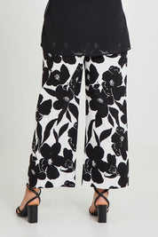 Model Terri-Leigh wearing size 14 of The Printed Cotton Stretch Pant in colour Blkfloral (Black), from the back