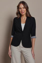 Model Madeline wearing size 10 of The Contrast Inner Cuff Blazer in colour Black (Black), from the front, cropped image