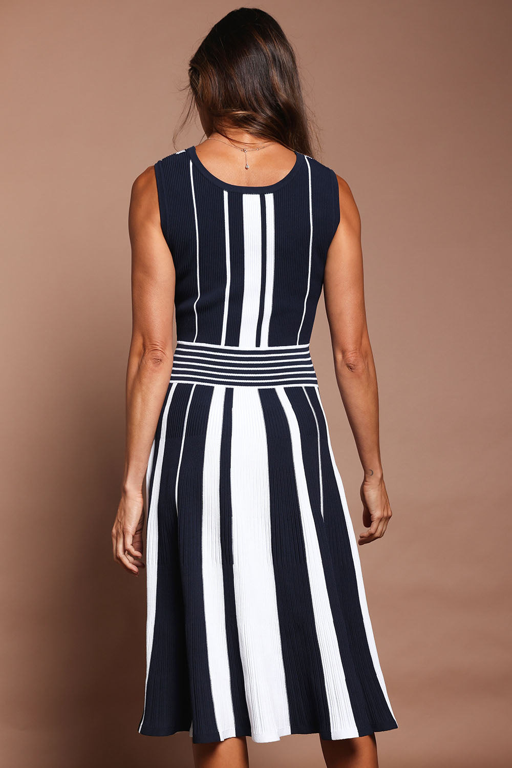Model Amanda wearing size S of The Reversible Knit Dress in colour Navystripe (Blue), from the back